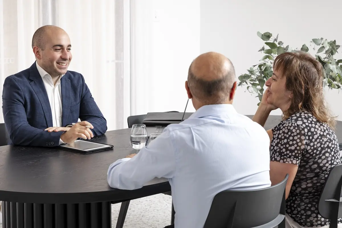 Robert Daniele sitting in an interview with a couple talking about retirement.