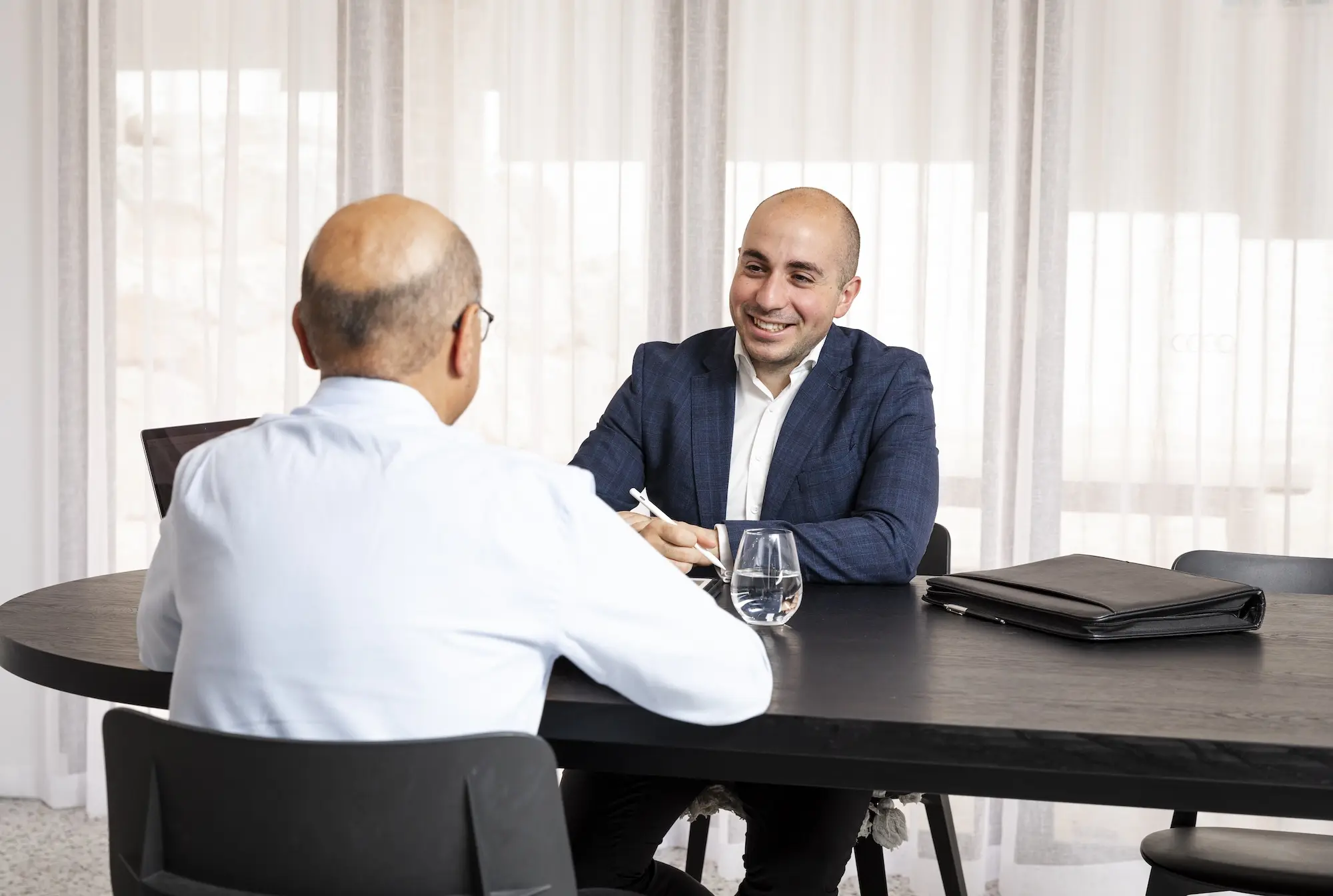 Robert Daniele smiling and talking with one of his clients.